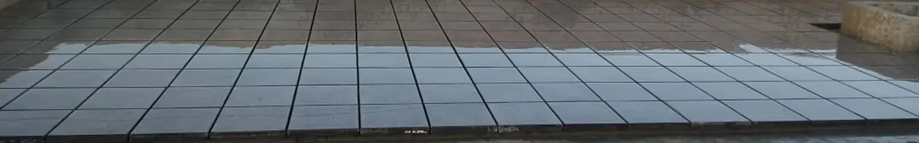 Cement finish roof heat insulation tiles laid in a close grid across a flat Karachi rooftop