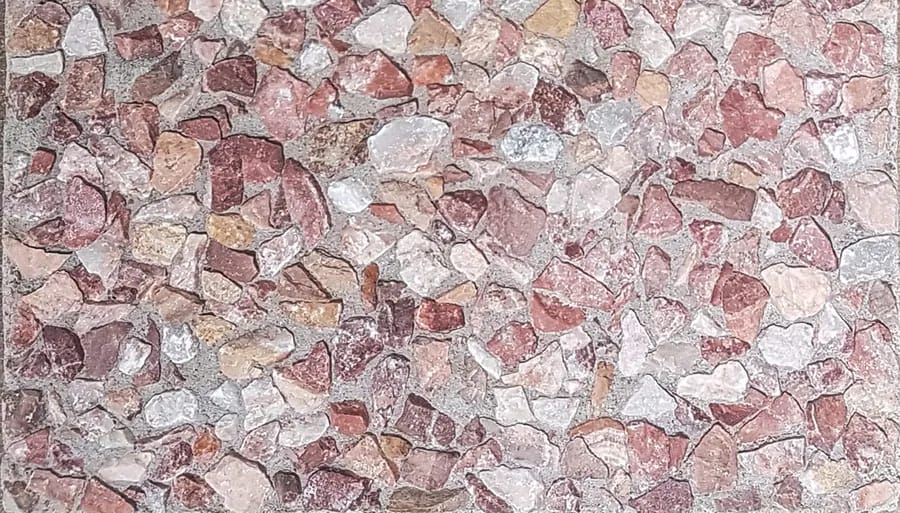 Washed terrazzo in pink and oxblood marble chip standing proud of a pale grey matrix
