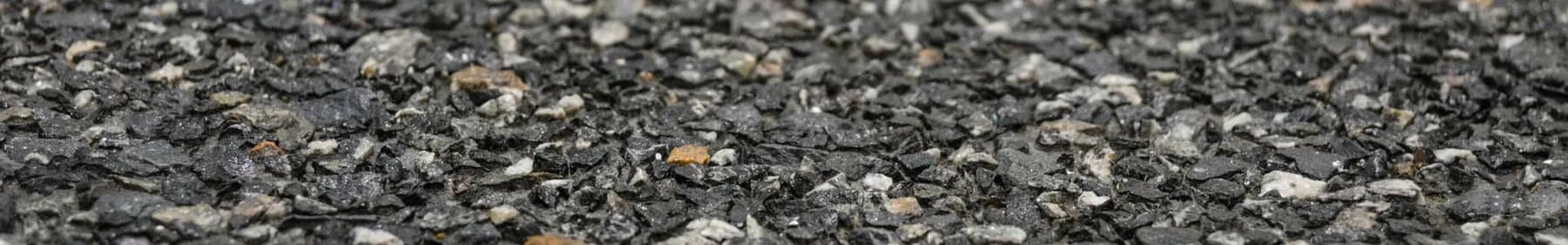 Washed terrazzo with dark aggregate standing proud of the cement matrix, pale grey and tan chips catching the light