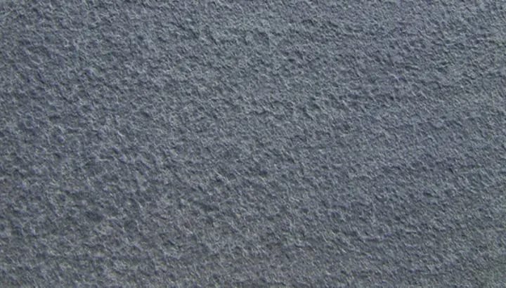 Flamed antique basalt, the face opened by heat into a coarse blue grey texture