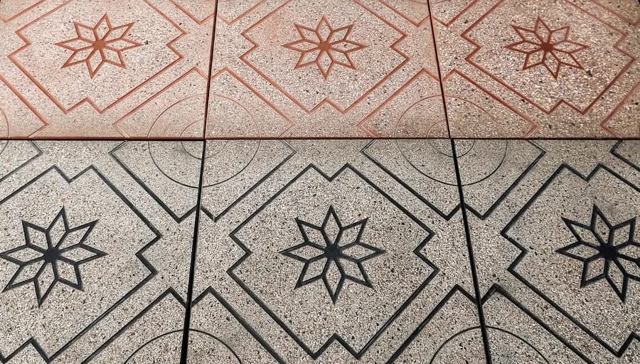 Grey exposed aggregate paving with a star pattern outlined in terracotta