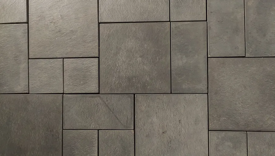 Grey concrete paving in mixed rectangular formats coursed into a repeating modular panel