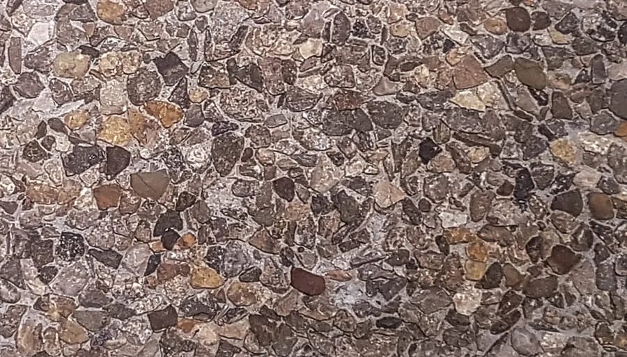 Washed terrazzo in dark brown and rust marble chip, densely packed in a brown matrix