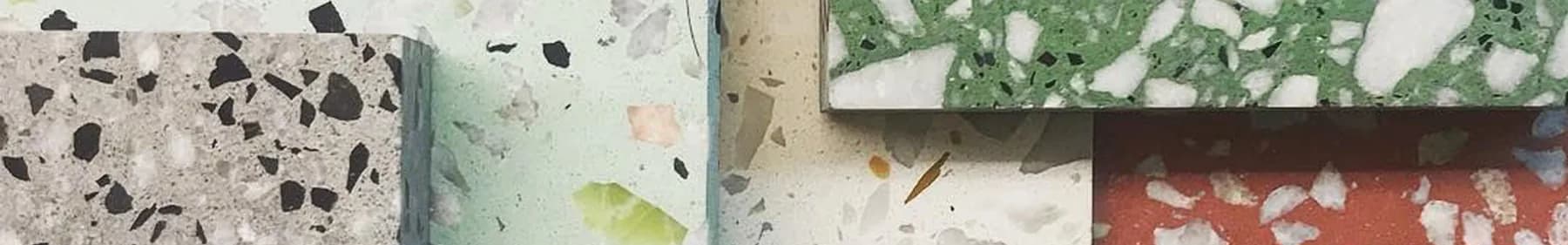 Polished terrazzo samples butted edge to edge in grey with black chips, mint green, bone and red with white marble aggregate