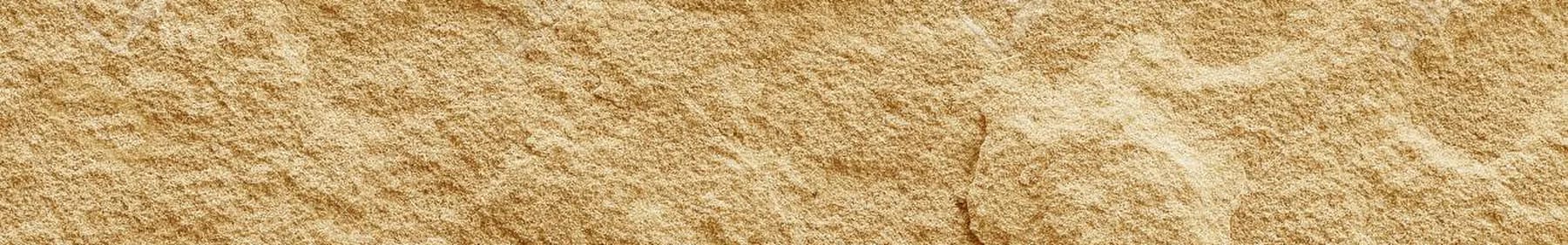 Sandstone with warm sedimentary banding across a naturally cleft face