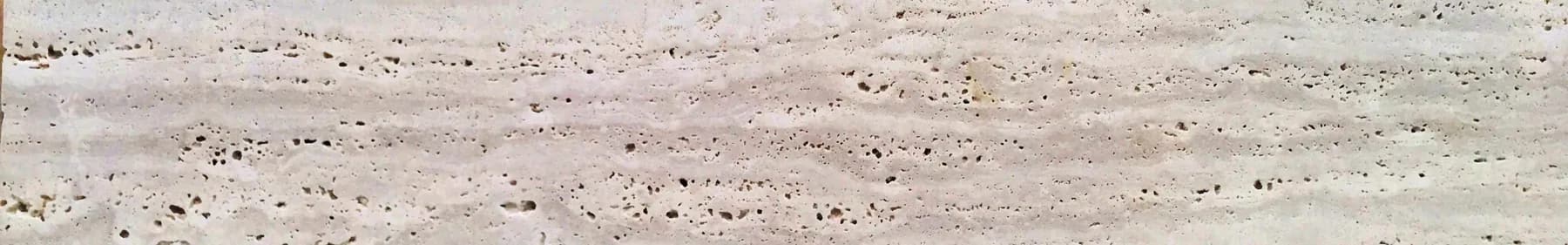 Travertine surface showing the characteristic open pore structure that limestone does not have
